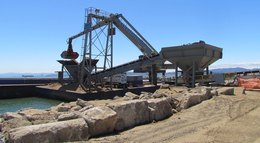 Off loading soil from barge for Site 2 soil cover at Alameda Point.  Southern shoreline.