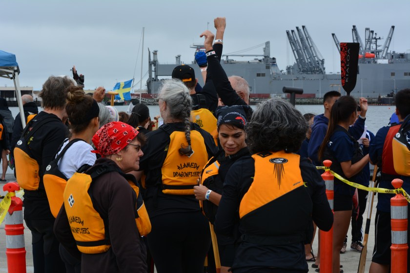 Dragon boat team huddling at Seaplane Lagoon