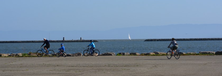 Family bicycling to the shoreline on west side of Seaplane Lagoon.