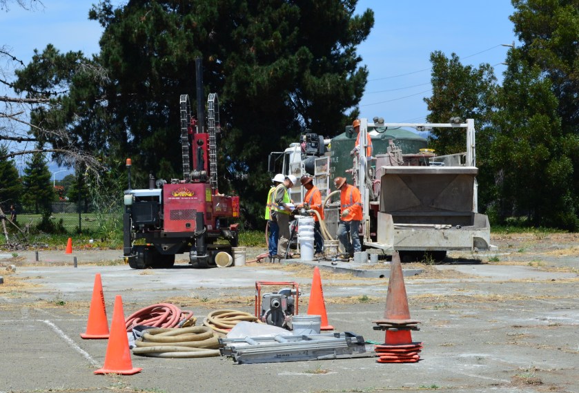 Workers at the old gas station and car wash site on West Pacific Avenue on July 13, 2015 preparing to inject cleanup solutions into the ground. The Navy operated a gas station and car wash on the site from 1971 to 1980. Green tank on truck contains non-potable water for on-site mixing of treatment solution. Soccer field is in the background.