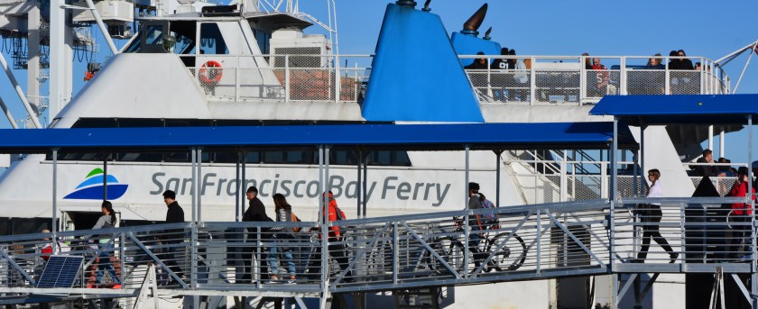 Ferry passengers boarding at the Alameda Main Street Terminal bound for San Francisco. The popular Main Street Terminal at the north side of Alameda Point on the Oakland Estuary will continue in operation, even if new ferry service comes to the Seaplane Lagoon. Parking here will be expanded in mid-2016.